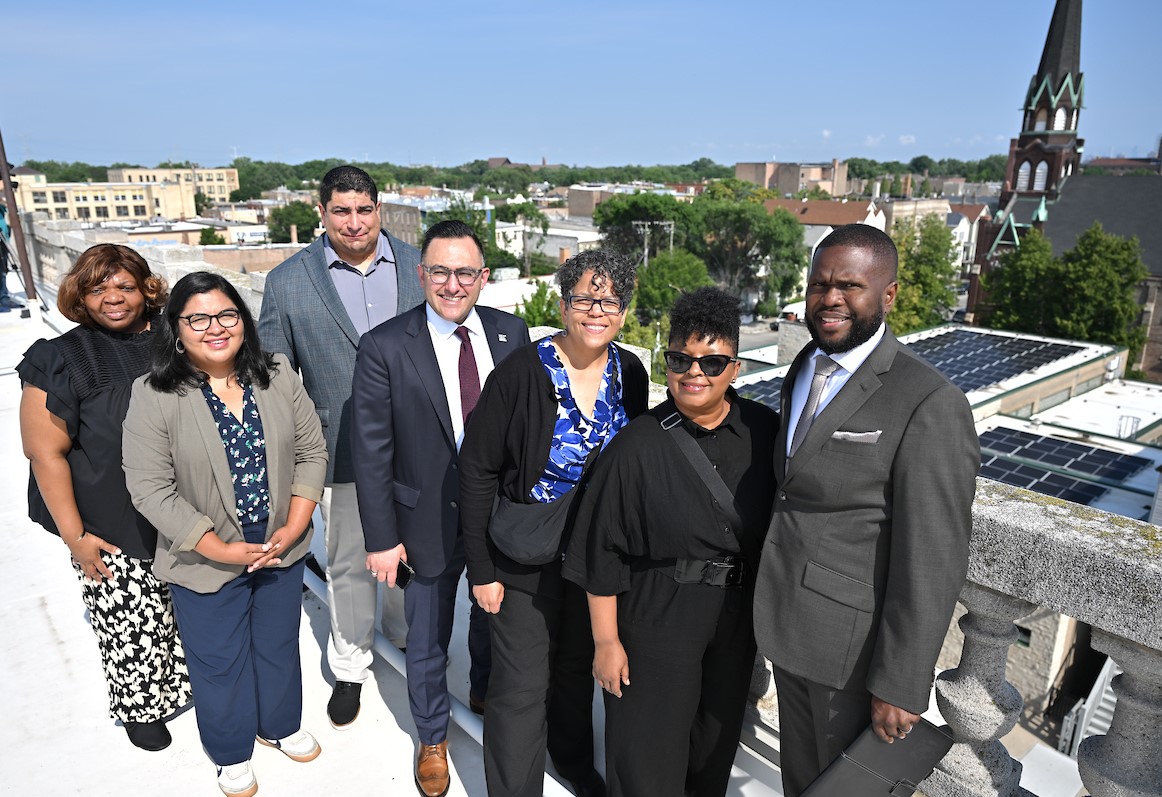 Group of City officials and others with solar panels visible in background